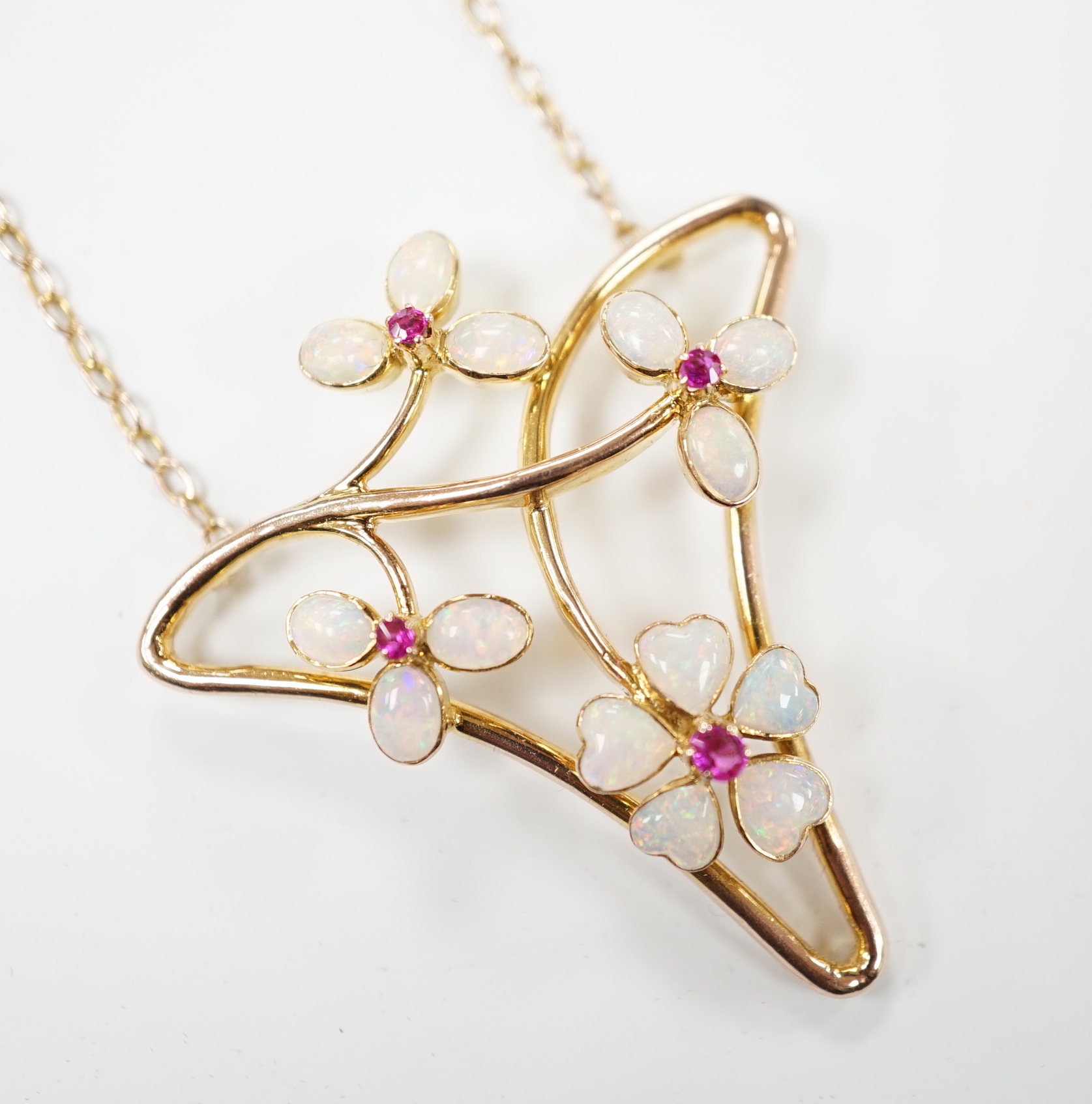 A yellow metal ruby and white opal set Art Nouveau style necklace, in Carrington & Co. box, 4cm
